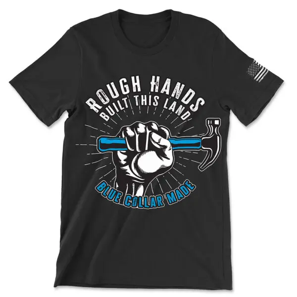 Black t-shirt with white text in circular shape "Rough hands" with "Built this land" directly below it at the top of the circle with "Blue collar made" in blue text with black and white outline at the bottom of the circle. A white and black fist gripping a hammer with a blue handle emerges from the bottom text into the center of the circle shape. White lines come from all around the fist moving toward the outside of the circle. Features white worn American flag on left sleeve.