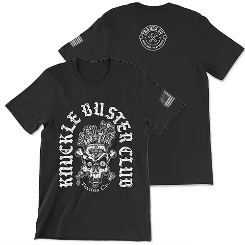 Black T-shirt with white design. "Knuckle Busters Club" I written in an curved lowercase n shape with a skull and crossbones with tools coming from the head in the center. Trades Co. is written bellow the skull. White American flag featured on the left sleeve. Small white Trades Co. Logo featured on the upper center back of the t-shirt.