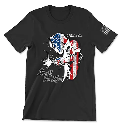 Black t-shirt featuring a welder filled with American flag design. "Trades Co." above and "Built To Last" script below. Worn American Flag in white on left sleeve.